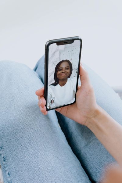 A young woman smiles during a video call on a smartphone, showcasing modern technology and communication.