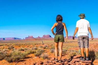 Free photo beautiful young european couple enjoying the beautiful view of famous monument valley in utah, usa