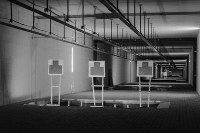 Black and white image of targets at an indoor shooting range with linear perspective.