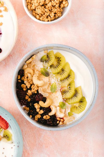 Delicious yogurt bowl topped with kiwi, blackberries, cashews, and granola.