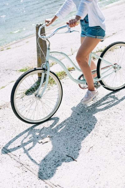 Female riding a bike along the beach