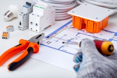 Electrician working with electrical scheme