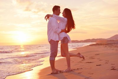 Happy young romantic couple in love have fun on beautiful beach at beautiful summer day