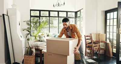 Man packing cardboard boxes in a bright Texas home while preparing for a move.