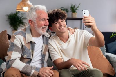 Free photo medium shot man and grandpa taking selfie