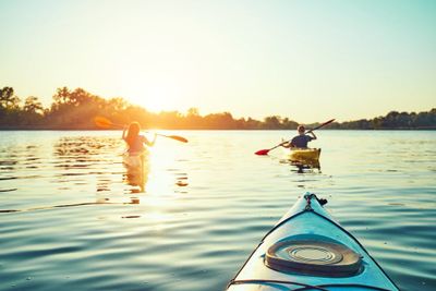 People kayak during sunset in the background. have fun in your free time.