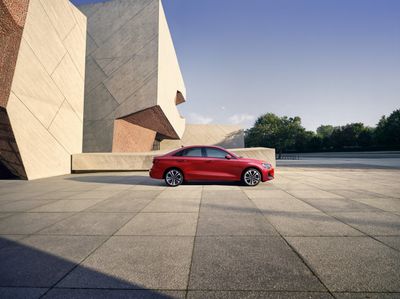 2025 Audi A3 side profile in red parked near modern architecture