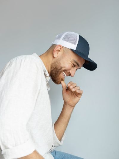 Smiley man posing with trucker hat side view