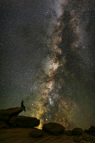Stunning Milky Way over Horseshoe Bend with a silhouetted figure, perfect for cosmic exploration themes.