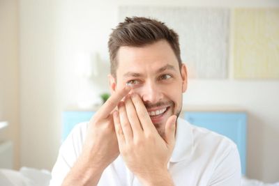 Hand of young man with contact lens