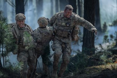 Army Ranger recruits running through forest during training mission in War Machine on Netflix