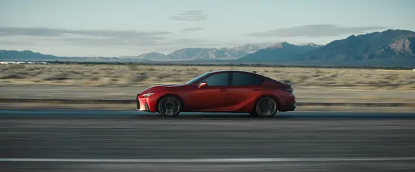 2025 Lexus IS 500 F SPORT Performance in Infrared driving through the desert with mountains in the background