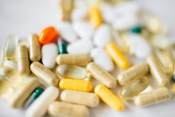 A close-up image of various pills and capsules showcasing diverse colors and types of pharmaceuticals.