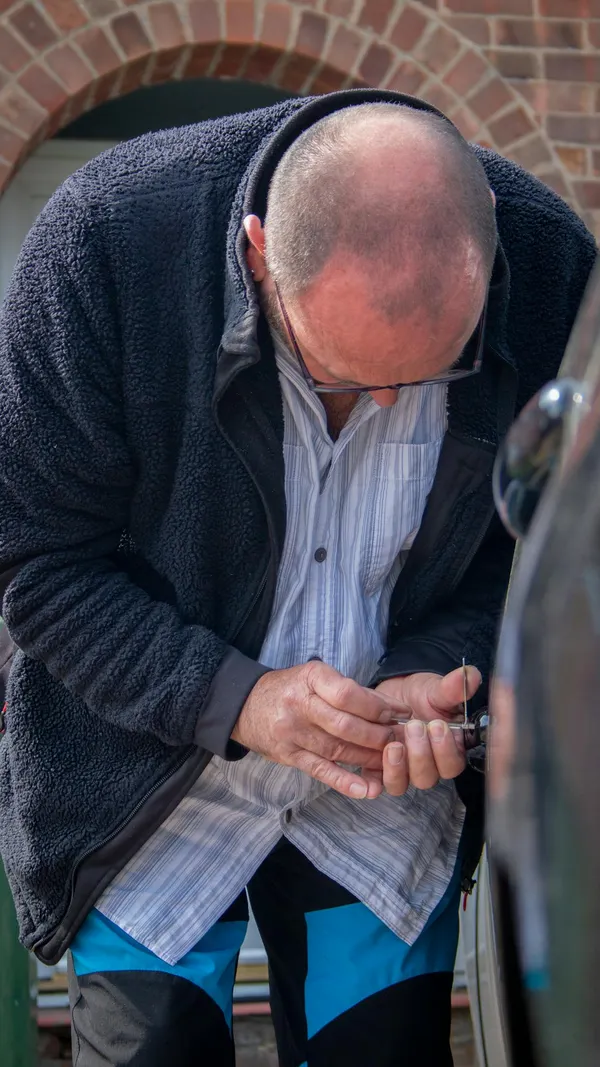 A locksmith works on unlocking a car, demonstrating his expertise and tools.