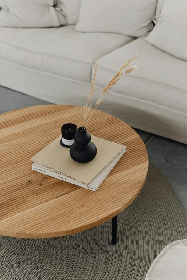 A minimalist coffee table with books and a black vase in a modern living room. Perfect for interior design inspiration.