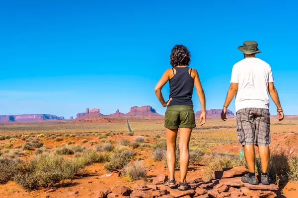 Free photo beautiful young european couple enjoying the beautiful view of famous monument valley in utah, usa