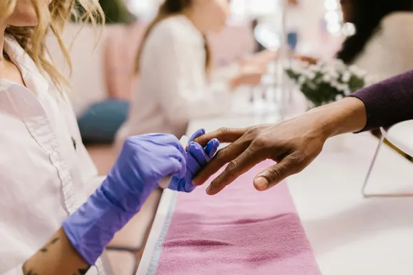 Close-up of a manicurist applying polish in a stylish nail salon.