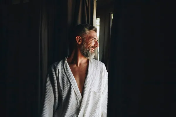 Cheerful man in a bathrobe - silver fox man
