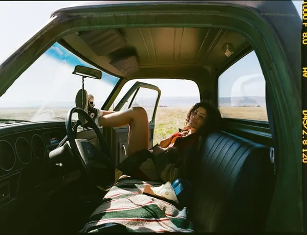Zendaya reclining inside a pickup truck, representing risky behavior and mature situations depicted in the show Euphoria.