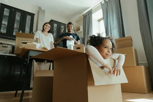 Family enjoys a joyful moment while unpacking boxes in their new kitchen.