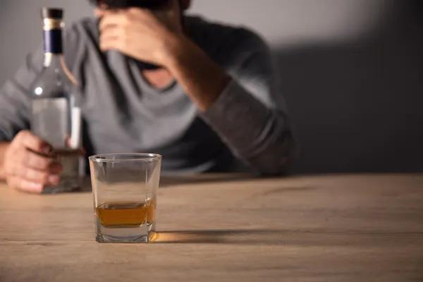 Handsome depressed man drinking whiskey