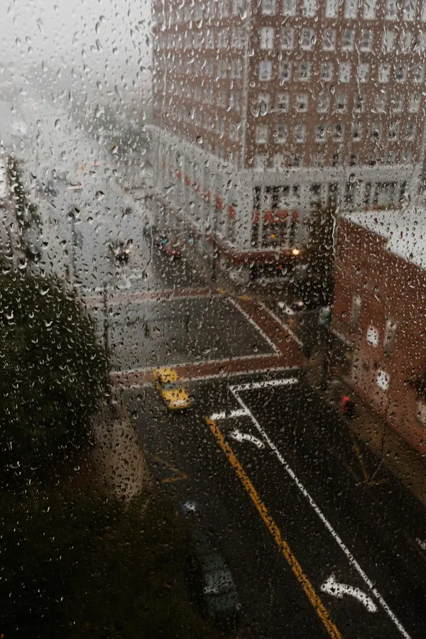 Rainy view of Greensboro NC through droplets on a window, showcasing urban atmosphere.