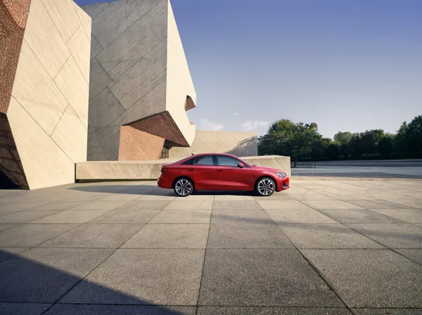 2025 Audi A3 side profile in red parked near modern architecture