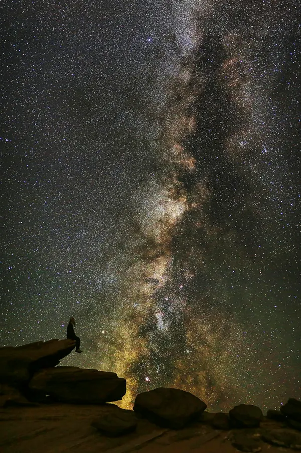 Stunning Milky Way over Horseshoe Bend with a silhouetted figure, perfect for cosmic exploration themes.