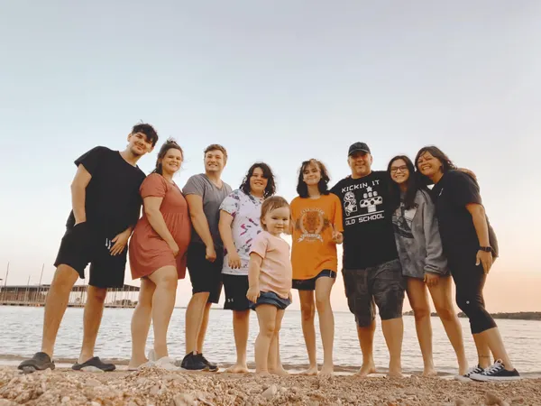 large family standing together on the beach showing strong family bond and parenting journey