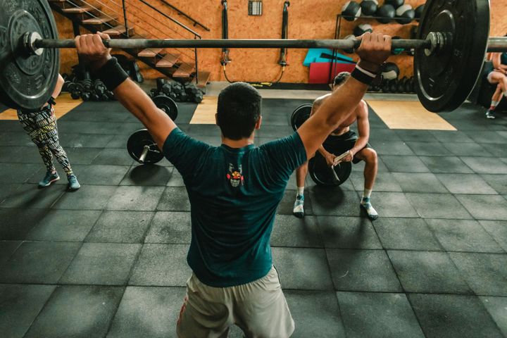 A group of men engaged in a vigorous weightlifting session at a gym.