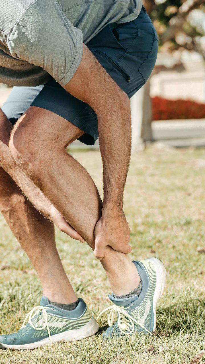 A Man Holding His Lower Leg
