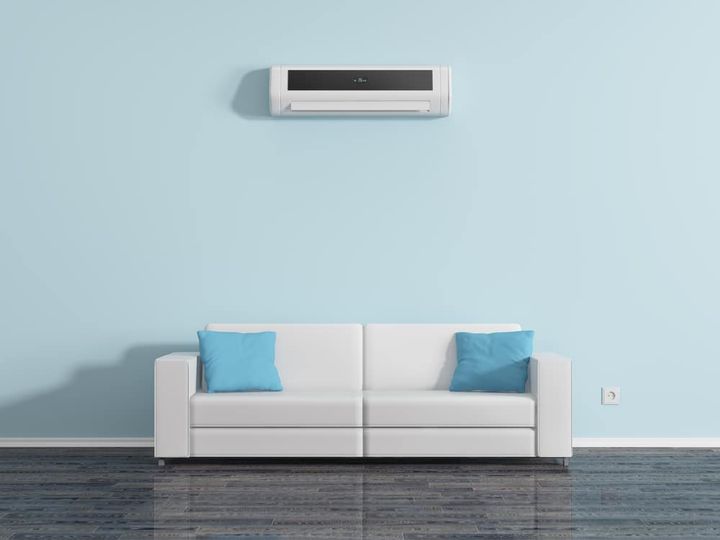 Air conditioning on the wall above the sofa cushions.