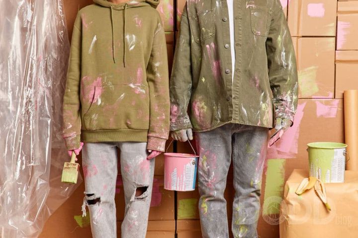 Cropped shot of dirty woman and man work as team holds paint bucket brushes painting house after relocation wear casual cloth
