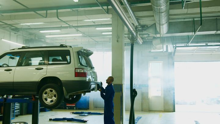 Man Holding the Rear Bumper of a Vehicle