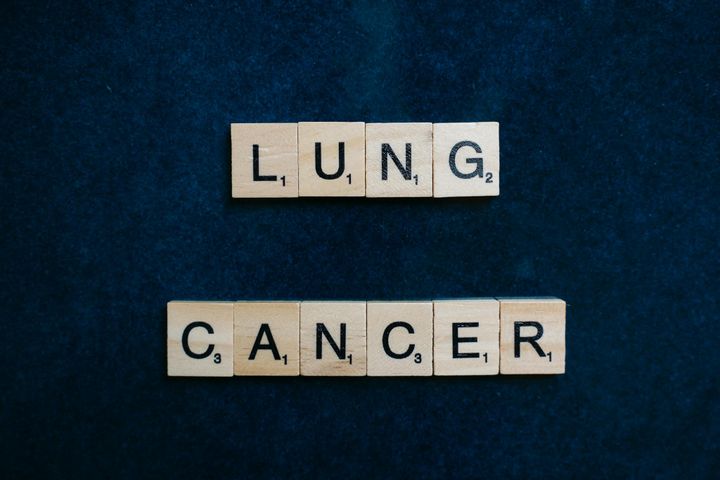Scrabble tiles spelling lung cancer on dark background symbolizing awareness.