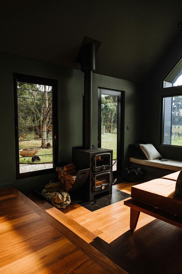 Warm living room featuring a modern wood stove and garden view.
