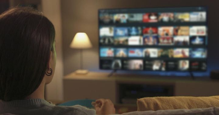 Photo young woman watching video on demand on her tv
