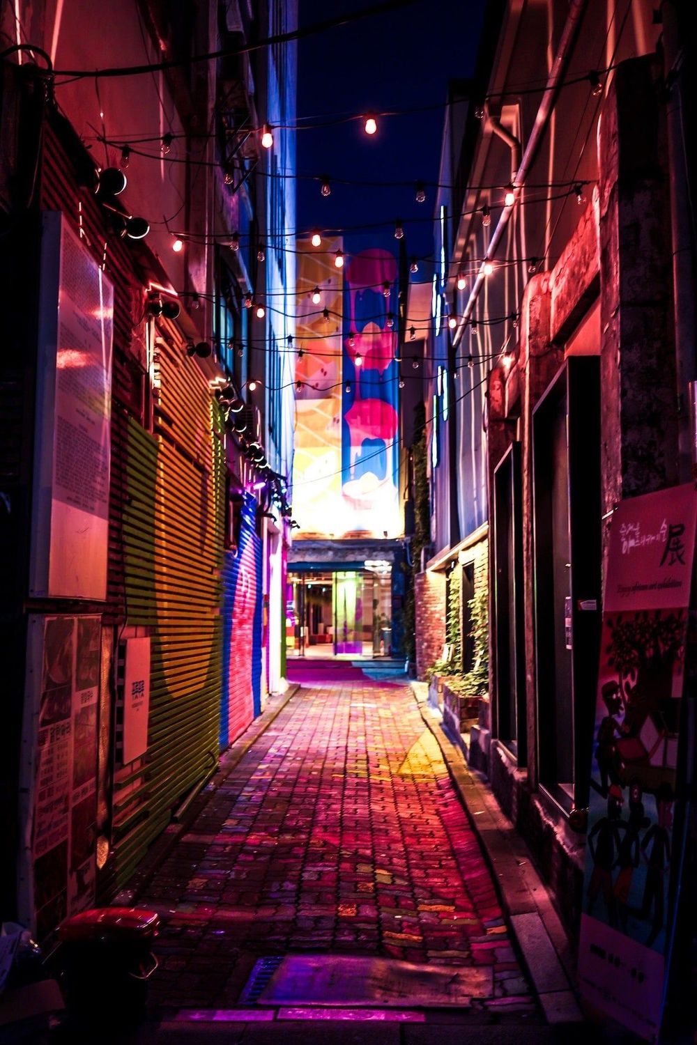 A photo of a street at night with bright signs