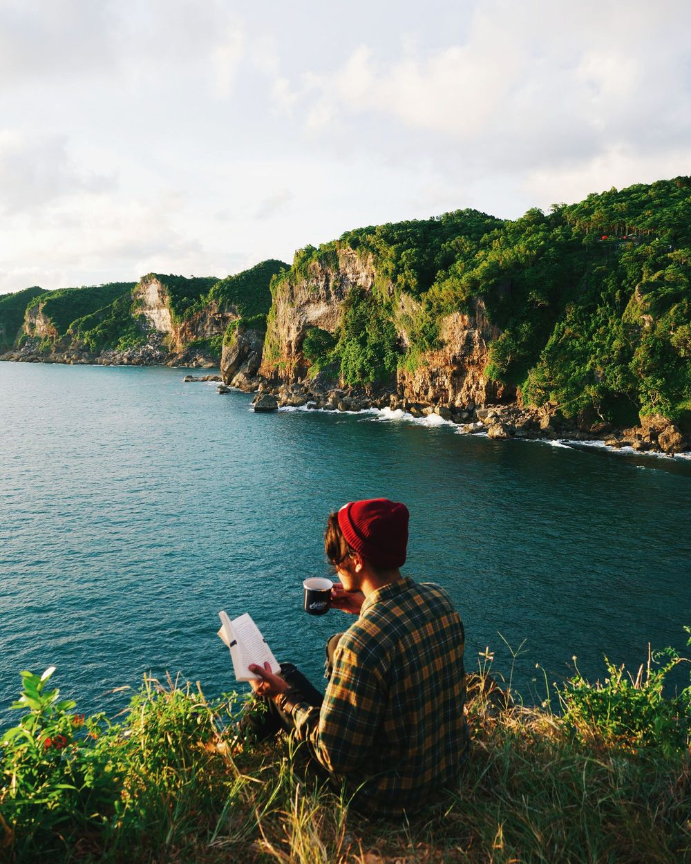 A photo of a designer sitting, drinking a flat white and thinking about beard oil