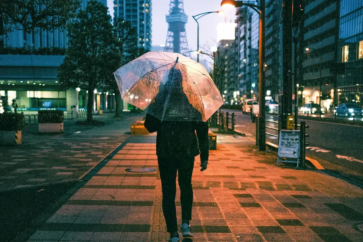 Man holding a clear umbrella on a Tokyo street