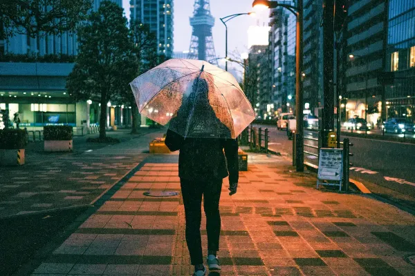 Man holding a clear umbrella on a Tokyo street