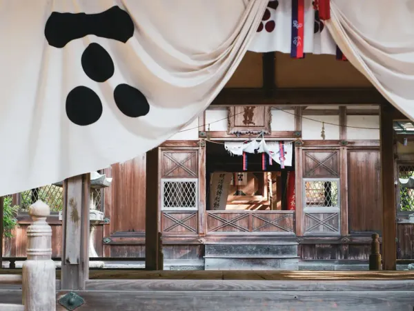 Wooden shrine entrance in Hagi, Japan with ceremonial white banners and kanji inscriptions