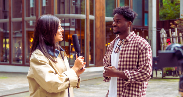Latina journalist interviewing young man.
