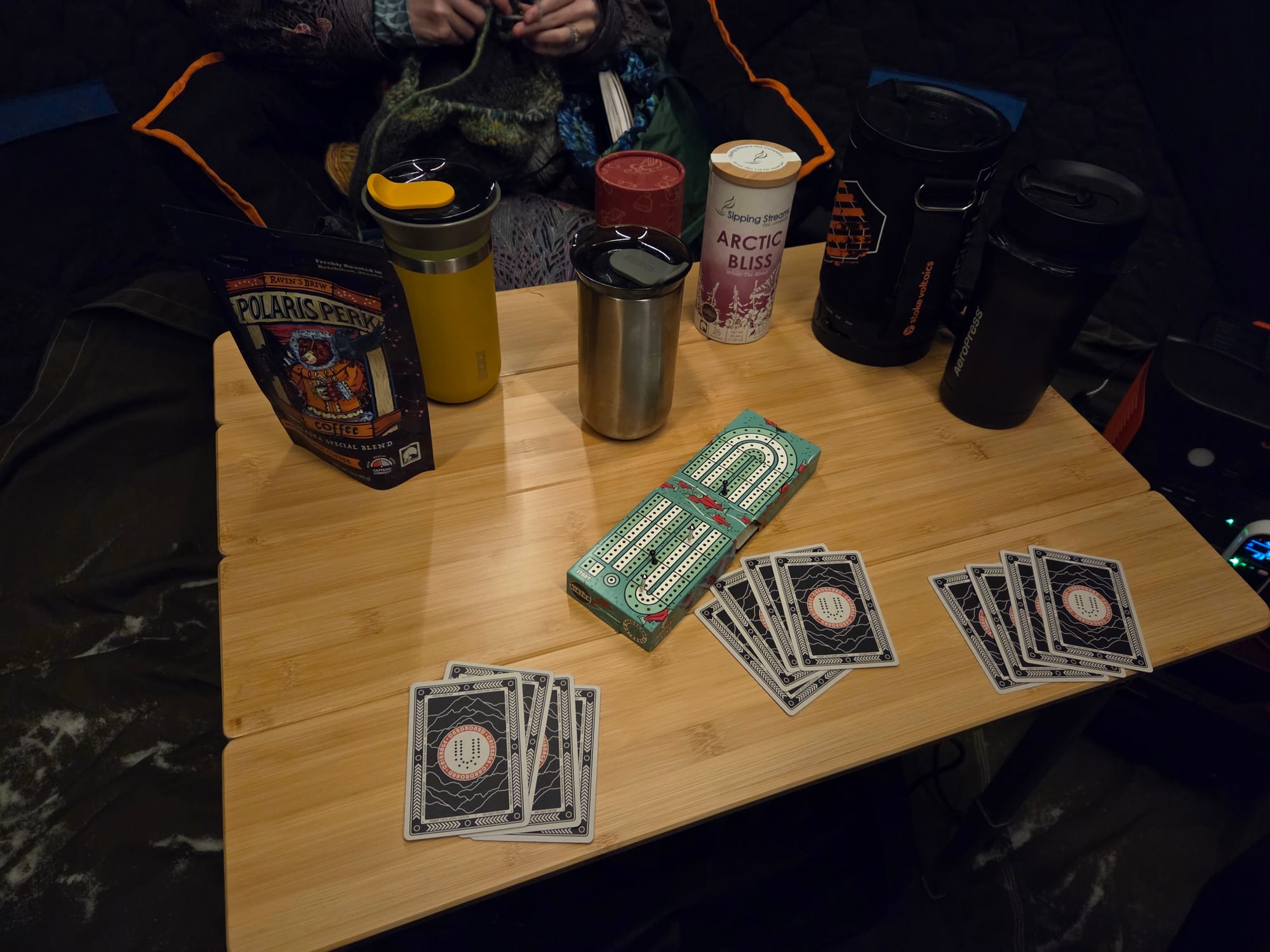 Coffee, tea, mugs and games on a table inside a cozy cold-weather tent in Alaska