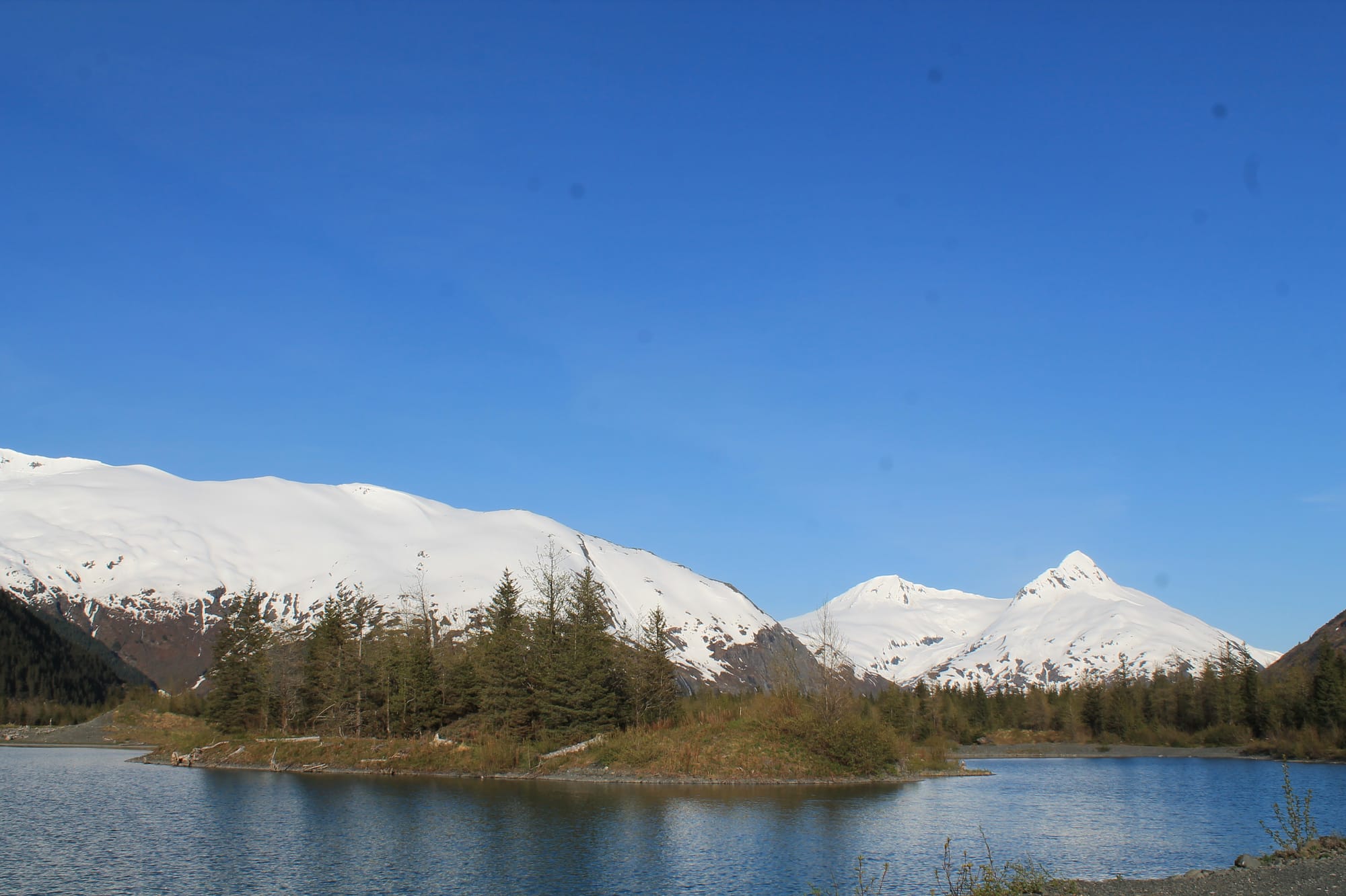 Snow-covered mountains and alpine lake along Alaska's scenic Seward Highway.