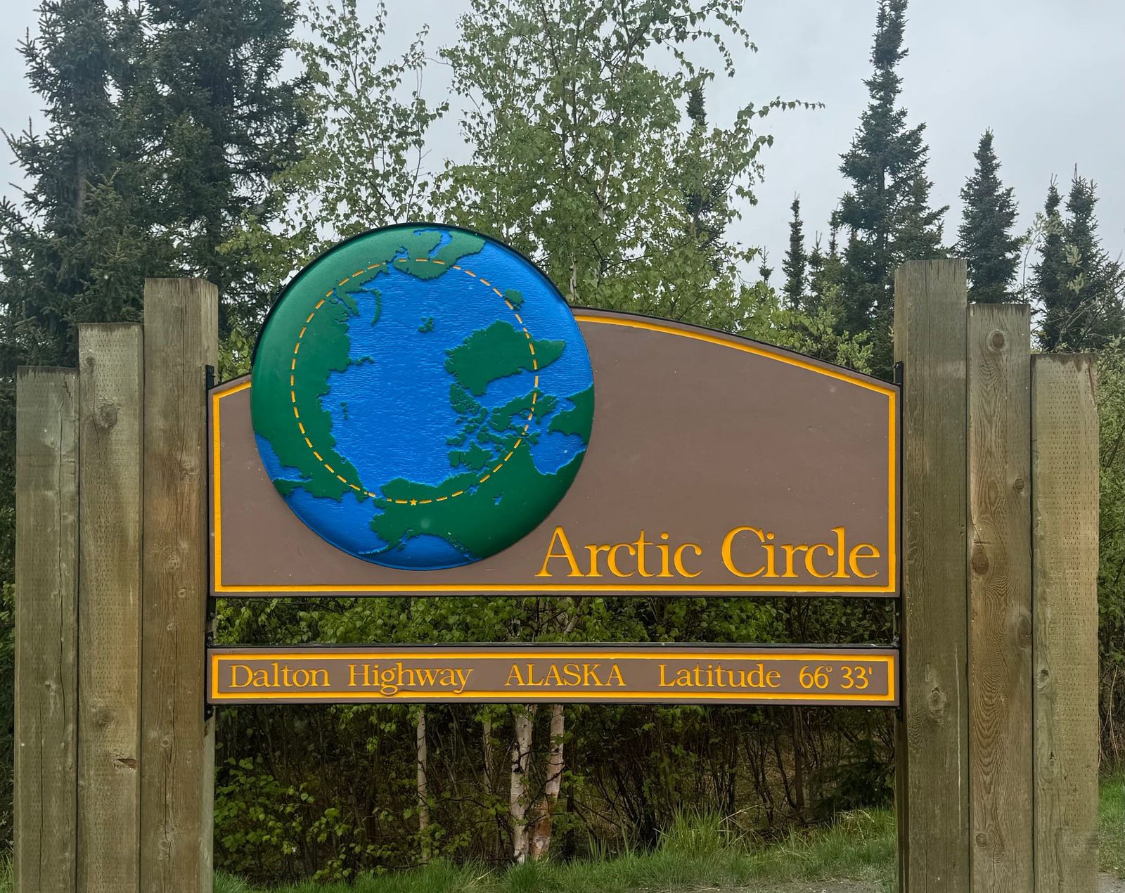 Arctic Circle sign on Dalton Highway Alaska at latitude 66°33′