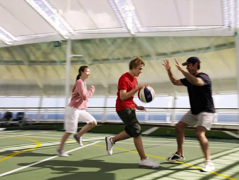 People playing basketball on a sports court on a cruise ship