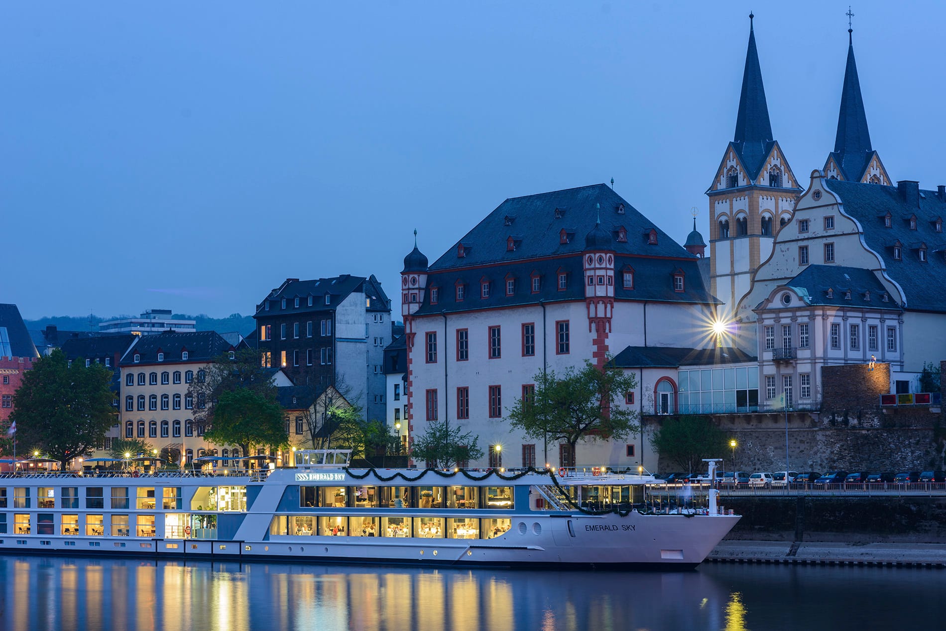 A river cruise ship sailing past Koblenz, a German city, at night