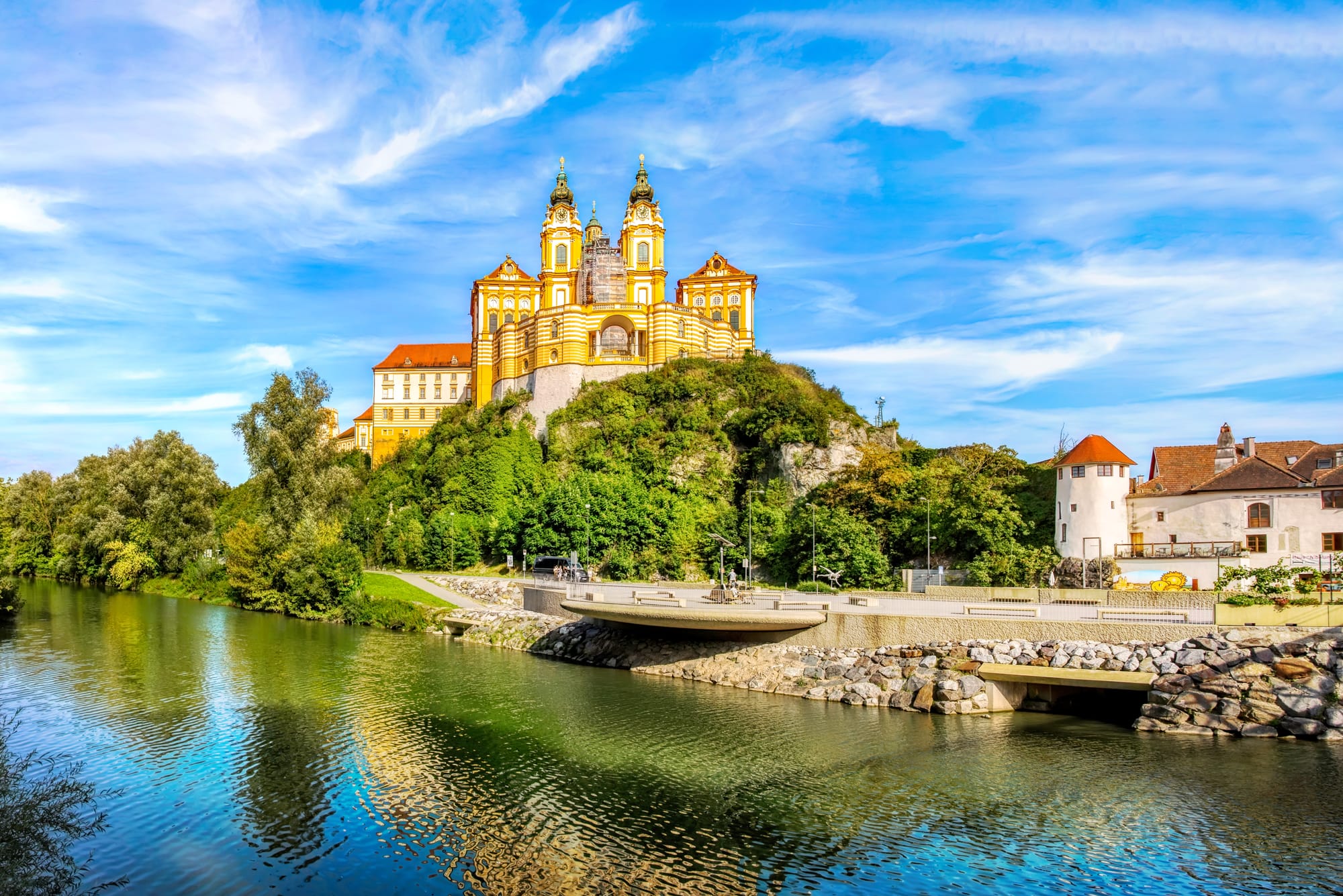 A view of Melk Abbey from the river on a sunny day with blue skies