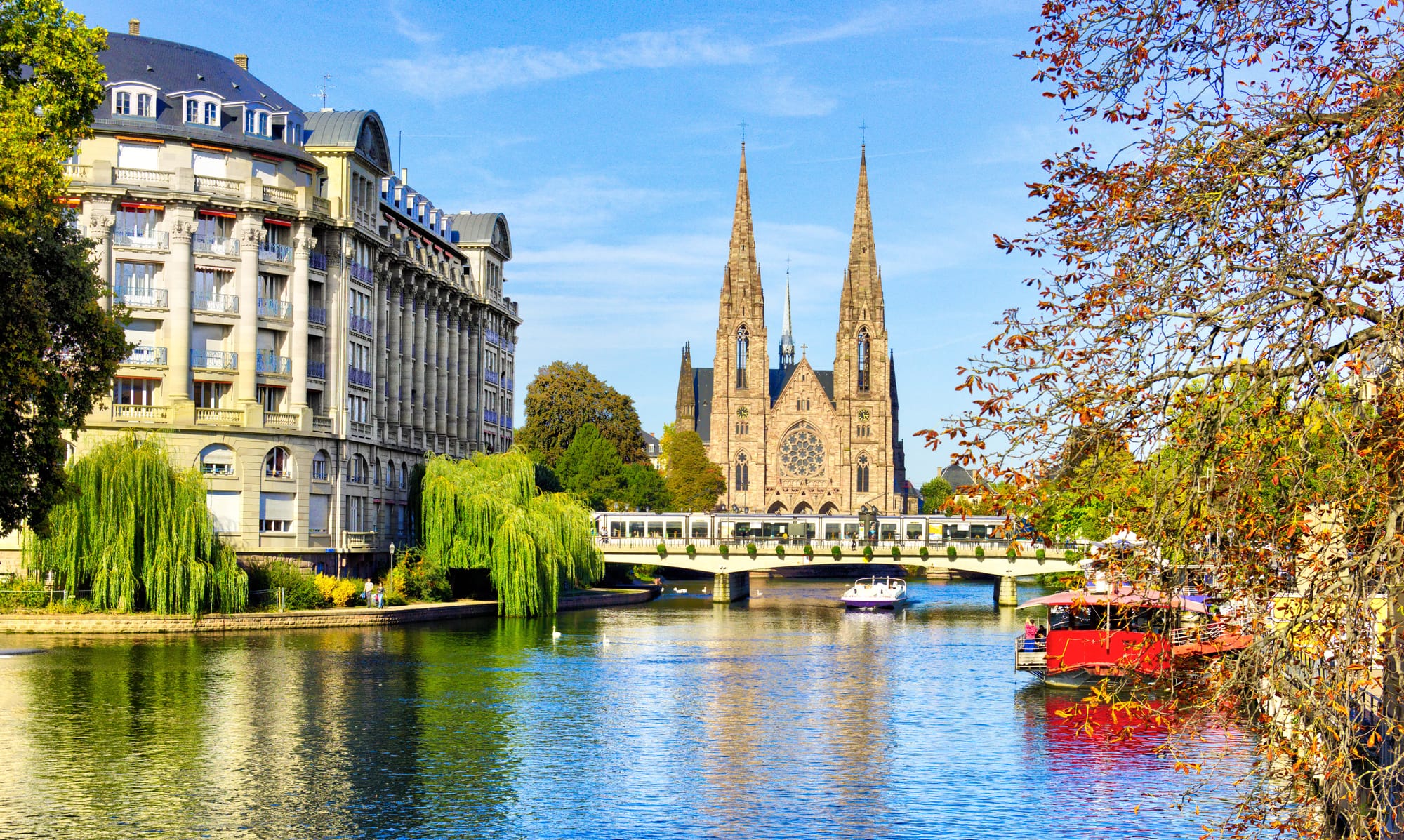 A look at a church in Strasbourg along a wide river during a sunny day